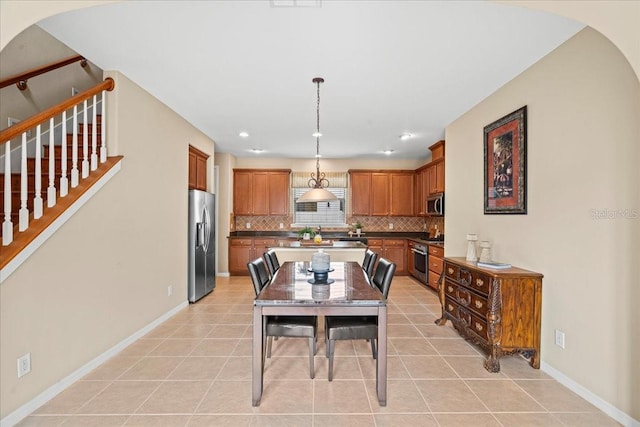20314 Chestnut Grove Dr, Tampa, FL 33647 - dining space with light tile patterned flooring, arched walkways, recessed lighting, baseboards, and stairway