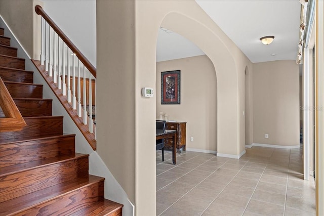 20314 Chestnut Grove Dr, Tampa, FL 33647 - staircase with baseboards, arched walkways, and tile patterned floors