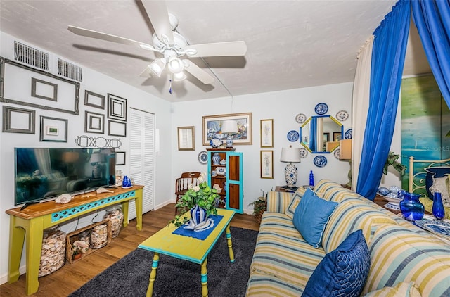 living room featuring ceiling fan, wood-type flooring, and a textured ceiling