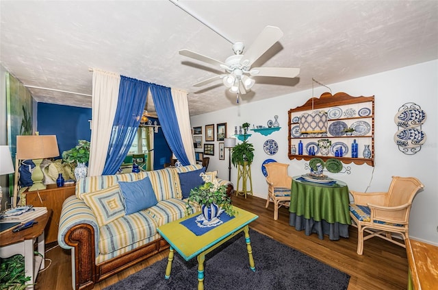 living room featuring ceiling fan, hardwood / wood-style floors, and a textured ceiling