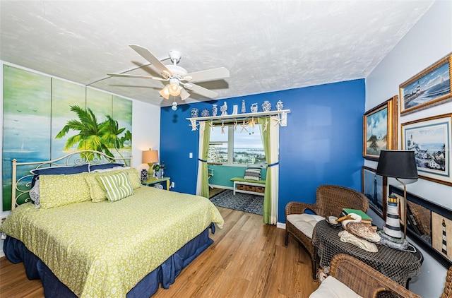 bedroom featuring ceiling fan, light wood-type flooring, and a textured ceiling