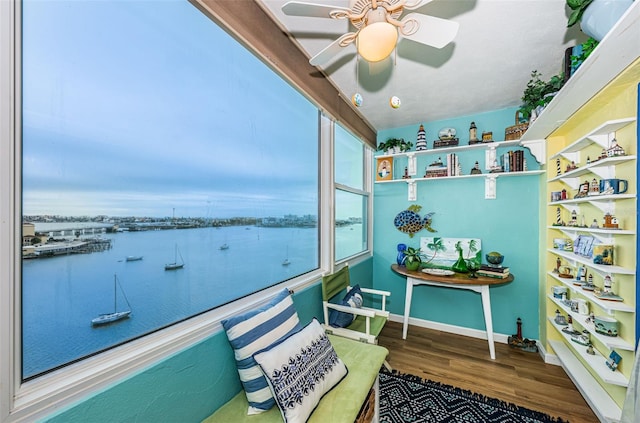 balcony with ceiling fan and a water view