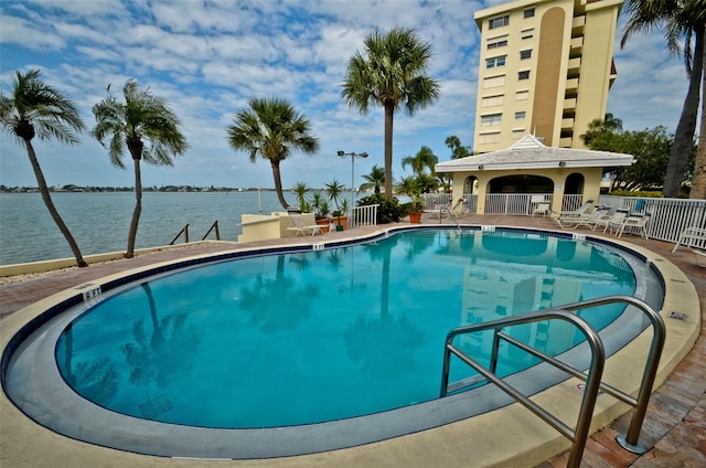 view of pool featuring a water view and a patio