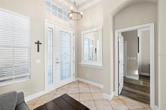 tiled entrance foyer with a chandelier