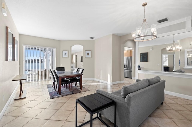 tiled living room featuring a notable chandelier