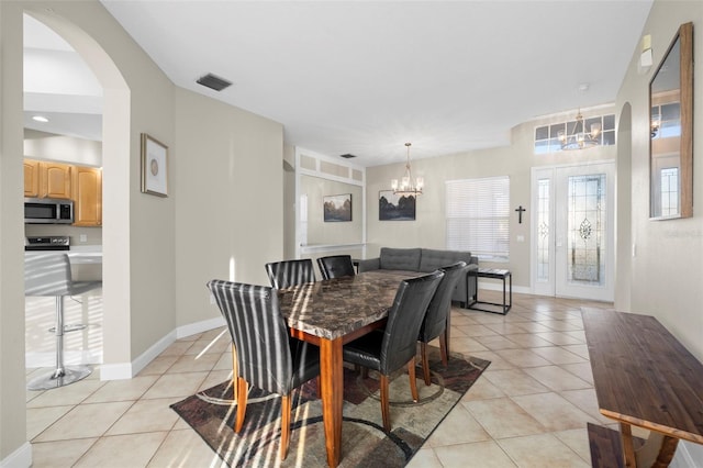 tiled dining room with a notable chandelier