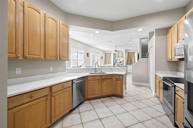 kitchen featuring sink, ceiling fan, light tile patterned floors, appliances with stainless steel finishes, and kitchen peninsula