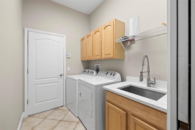 washroom with separate washer and dryer, sink, light tile patterned floors, and cabinets