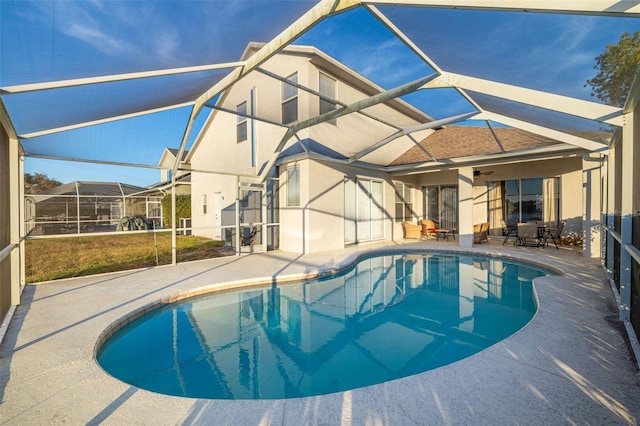 view of swimming pool featuring glass enclosure and a patio