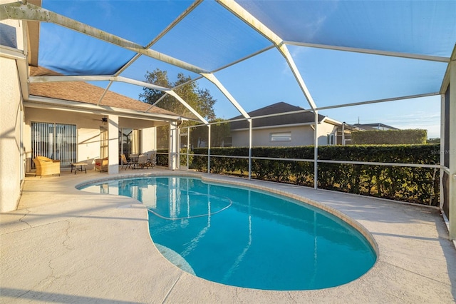 view of swimming pool featuring a patio, ceiling fan, and a lanai