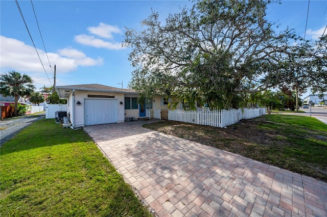 ranch-style house featuring central air condition unit, a front lawn, and a garage