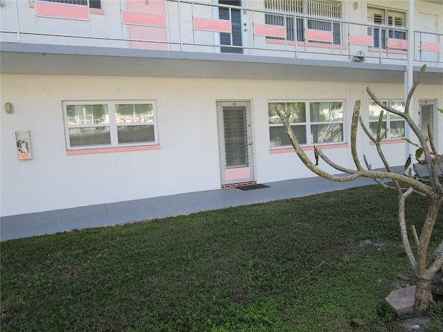 property entrance featuring a lawn