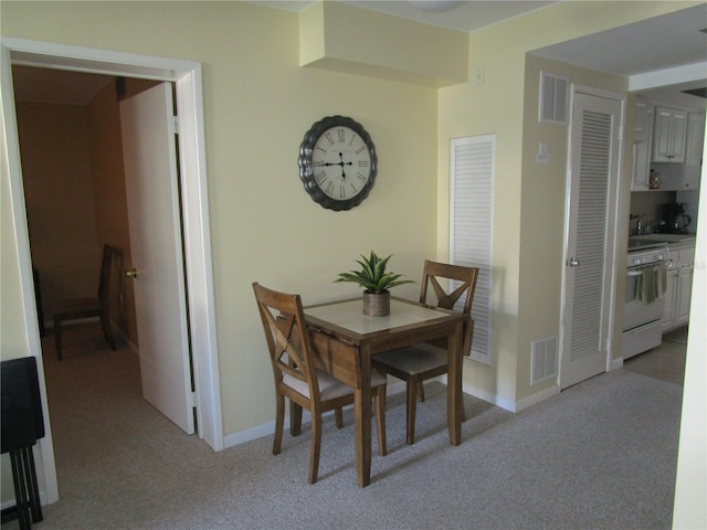 dining area featuring light carpet and sink