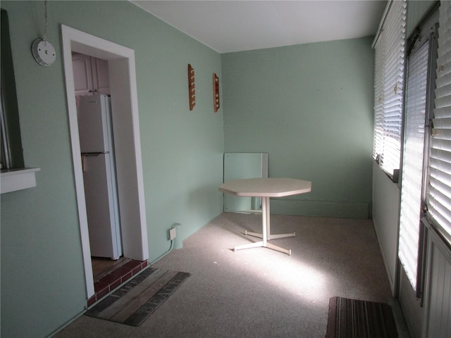 unfurnished bedroom featuring white refrigerator