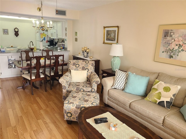 living room featuring light hardwood / wood-style flooring and a notable chandelier