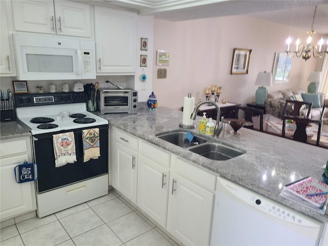 kitchen featuring white appliances, sink, decorative light fixtures, white cabinetry, and a chandelier