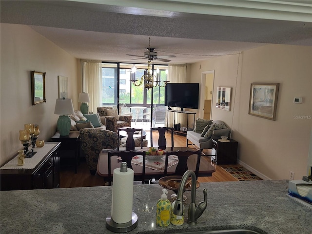 living room with hardwood / wood-style flooring and ceiling fan with notable chandelier