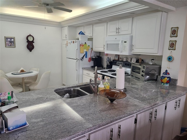 kitchen with white appliances, white cabinetry, and ceiling fan