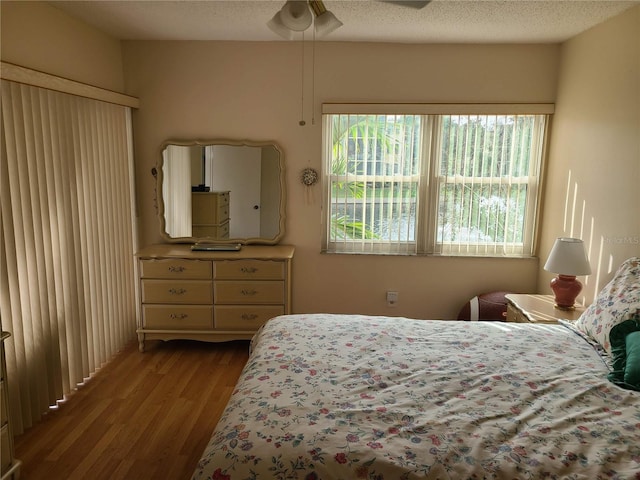 bedroom featuring ceiling fan, a textured ceiling, and light hardwood / wood-style flooring