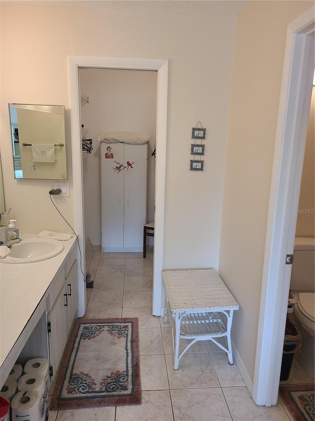 bathroom featuring tile patterned floors, vanity, and toilet