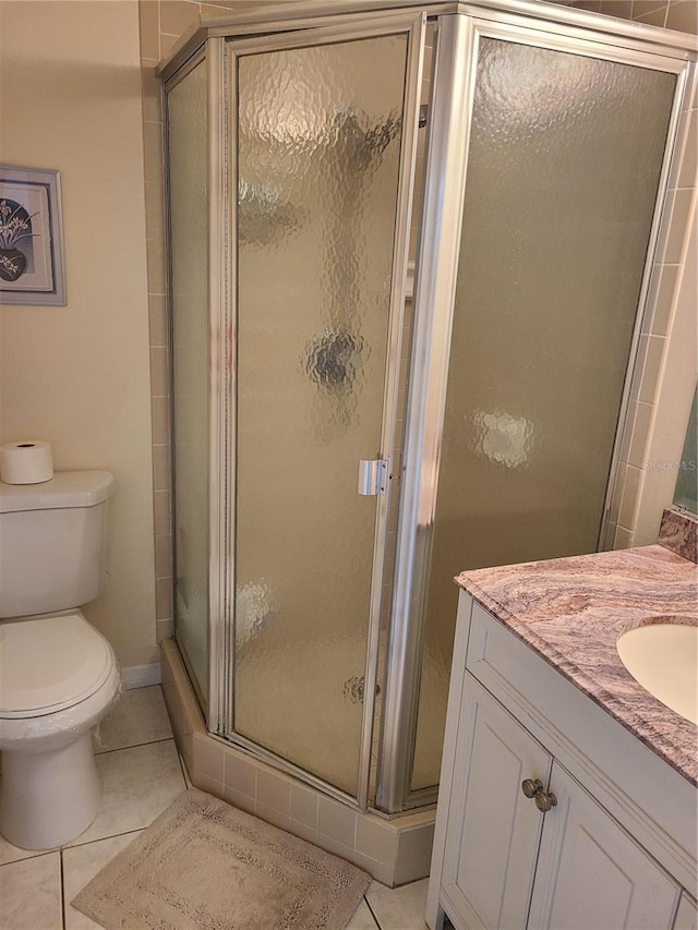 bathroom featuring tile patterned floors, vanity, toilet, and walk in shower