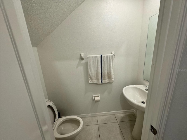 bathroom with toilet, tile patterned flooring, and lofted ceiling