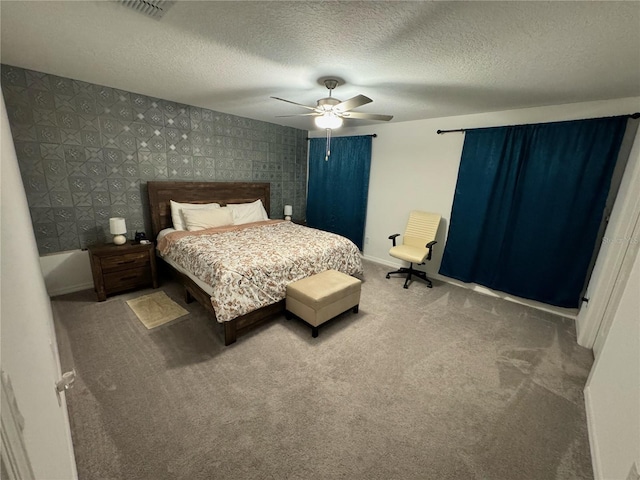 bedroom featuring ceiling fan, carpet floors, and a textured ceiling