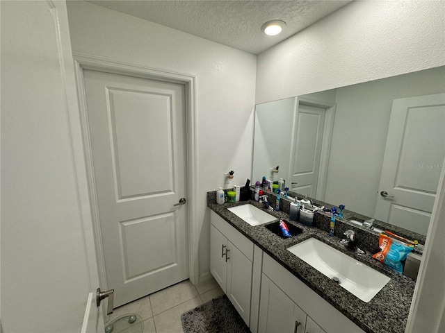 bathroom featuring a textured ceiling, tile patterned flooring, and vanity