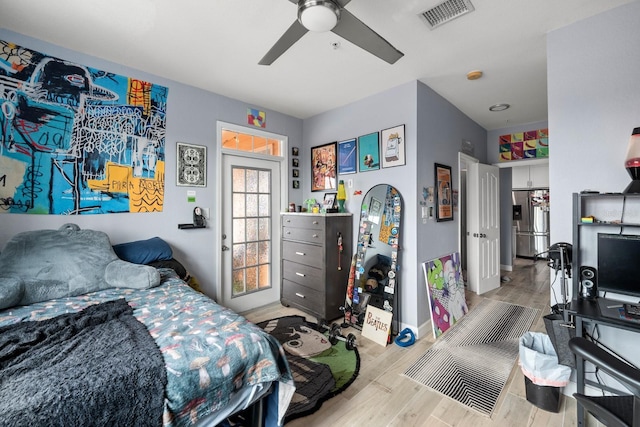 bedroom featuring ceiling fan, stainless steel fridge with ice dispenser, and light wood-type flooring