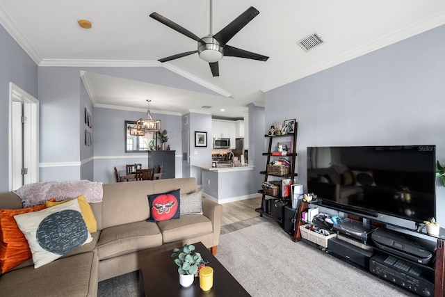 living room with ceiling fan with notable chandelier, light wood-type flooring, vaulted ceiling, and crown molding