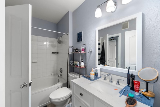 full bathroom with vanity, tiled shower / bath combo, and toilet