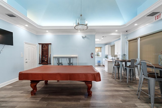 recreation room with pool table, a towering ceiling, crown molding, dark hardwood / wood-style floors, and an inviting chandelier