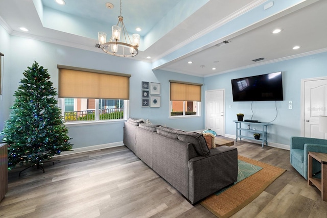 living room featuring crown molding, an inviting chandelier, and light hardwood / wood-style flooring