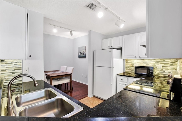 kitchen with decorative backsplash, a textured ceiling, sink, white fridge, and white cabinetry