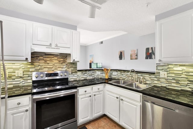 kitchen featuring white cabinets, sink, decorative backsplash, light tile patterned flooring, and stainless steel appliances