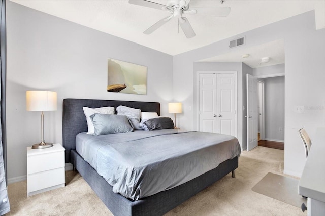 bedroom featuring ceiling fan, a closet, and light colored carpet