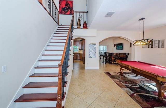 staircase with pool table, tile patterned floors, and indoor bar