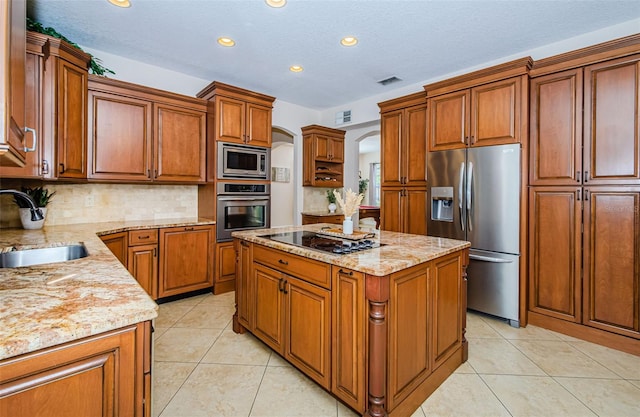 kitchen with a kitchen island, appliances with stainless steel finishes, sink, and light tile patterned floors