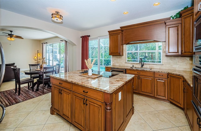 kitchen with a kitchen island, sink, backsplash, and appliances with stainless steel finishes