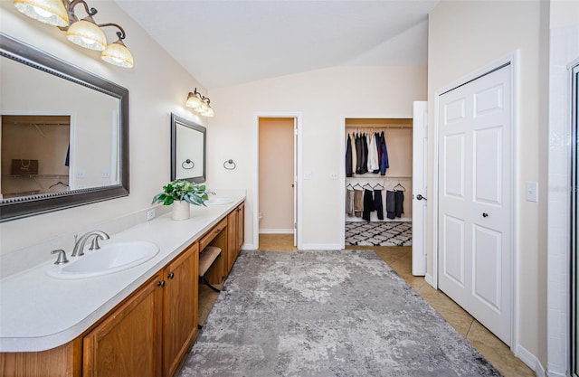 bathroom featuring tile patterned flooring, vanity, vaulted ceiling, a shower with shower door, and toilet