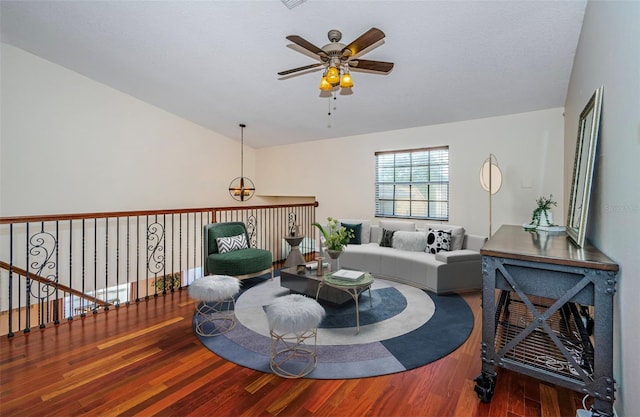 living room featuring ceiling fan, lofted ceiling, hardwood / wood-style floors, and a textured ceiling