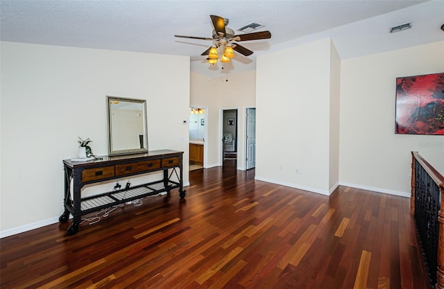 living room featuring dark hardwood / wood-style floors, a textured ceiling, and ceiling fan