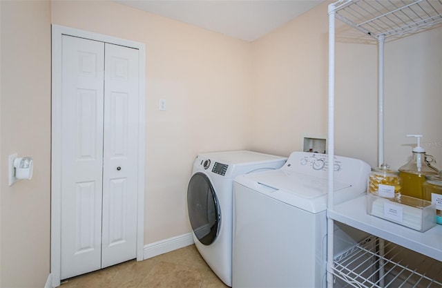 clothes washing area with light tile patterned flooring and independent washer and dryer