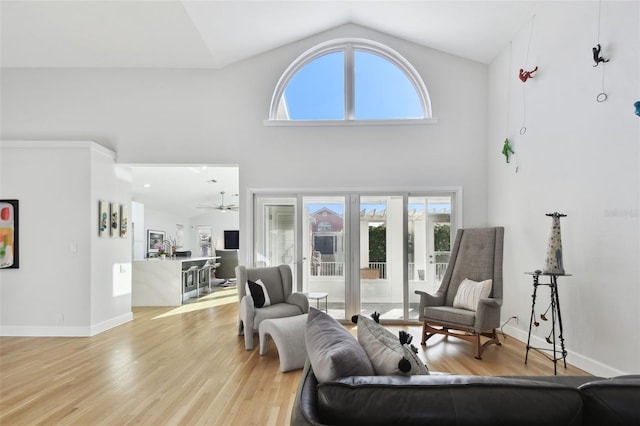 living room featuring ceiling fan, high vaulted ceiling, and light hardwood / wood-style floors