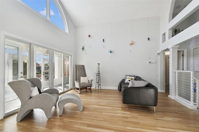 living area with hardwood / wood-style floors and a high ceiling