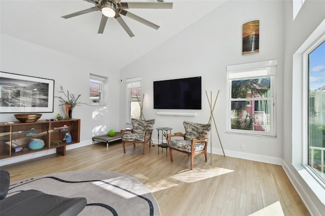 living room featuring ceiling fan, light hardwood / wood-style floors, and high vaulted ceiling