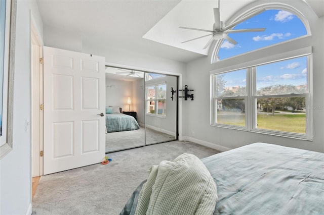 bedroom with ceiling fan, a closet, light colored carpet, and lofted ceiling