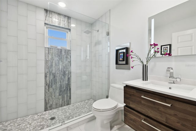 bathroom featuring vanity, toilet, and tiled shower