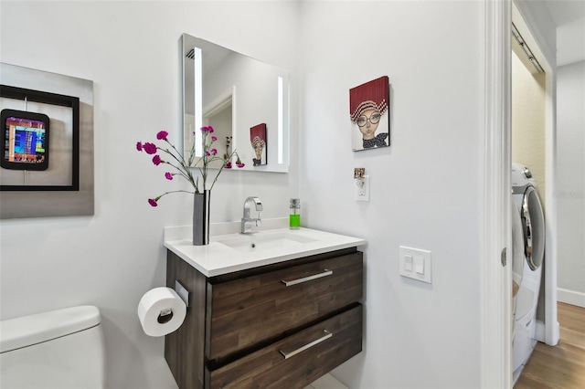 bathroom with washer / clothes dryer, vanity, and toilet