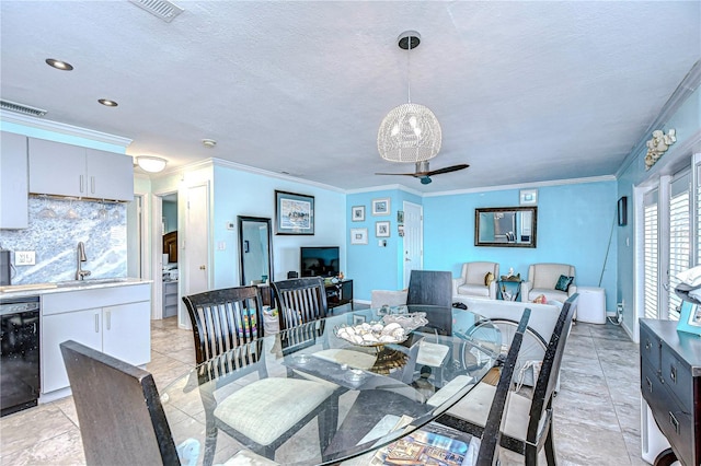 dining room featuring ceiling fan, sink, a textured ceiling, and ornamental molding